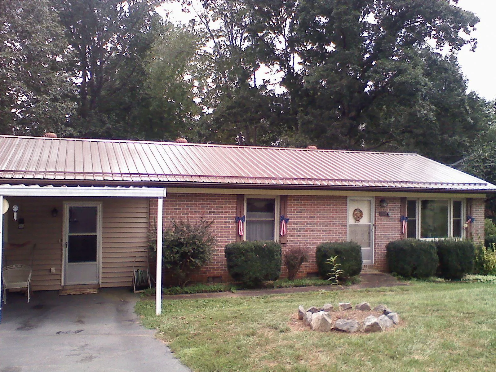 Bronze metal roof and carport on a brick ranch home — Roof Repair work by our crew in Eastham
